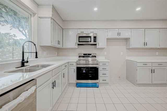 kitchen with stainless steel appliances, crown molding, sink, light tile patterned floors, and white cabinetry