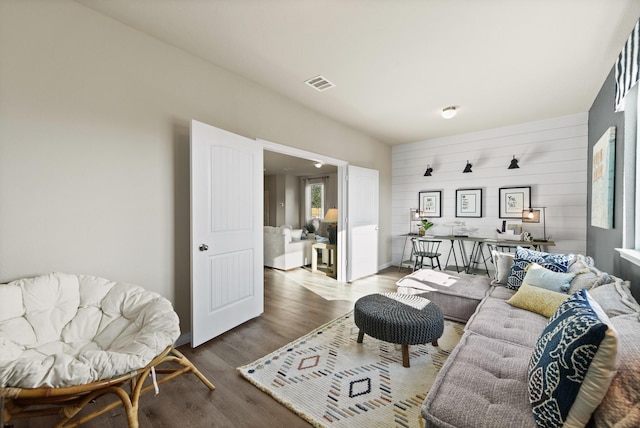 living room featuring hardwood / wood-style flooring and wooden walls