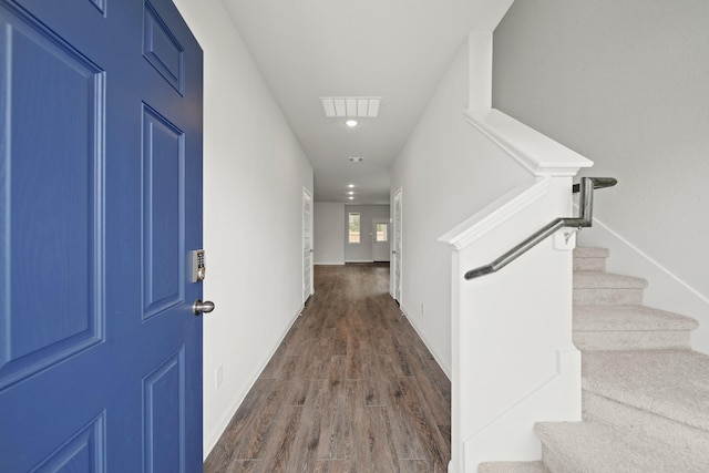 hallway featuring baseboards, visible vents, dark wood finished floors, stairway, and recessed lighting