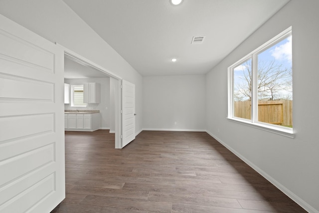 empty room featuring recessed lighting, dark wood-style flooring, visible vents, and baseboards