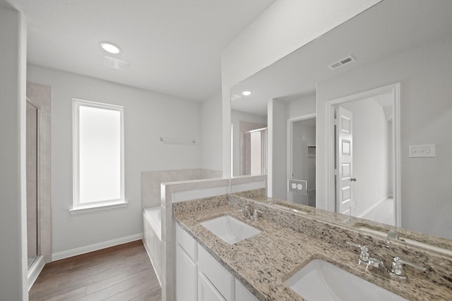 full bath featuring wood finished floors, a stall shower, a sink, and visible vents