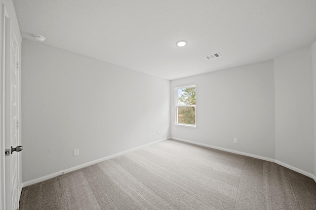 unfurnished room with baseboards, visible vents, and carpet flooring