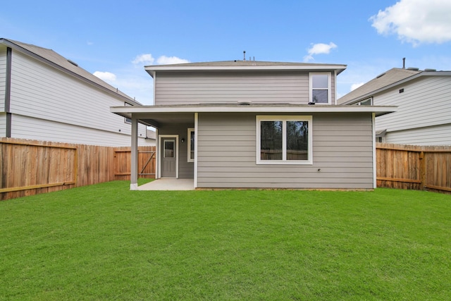 rear view of house featuring a yard, a patio, and a fenced backyard