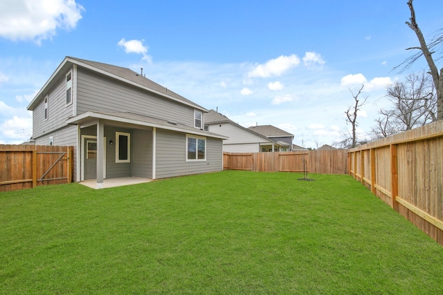 back of property featuring a lawn, a patio area, and a fenced backyard