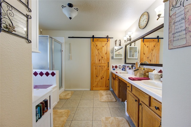 bathroom with vanity, a textured ceiling, tile patterned floors, and a shower with shower door