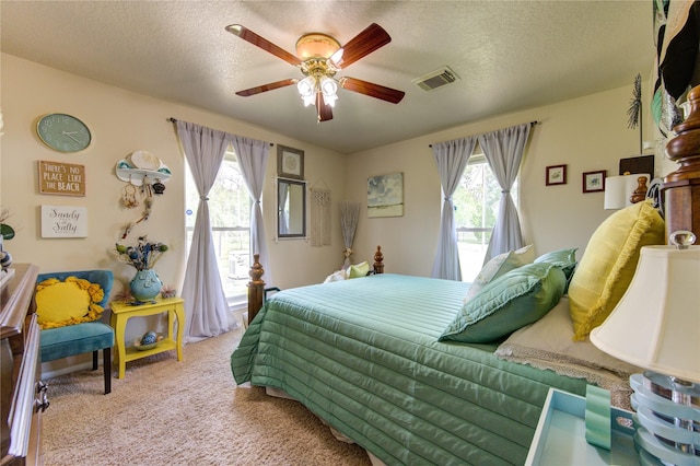 bedroom featuring multiple windows, ceiling fan, and a textured ceiling