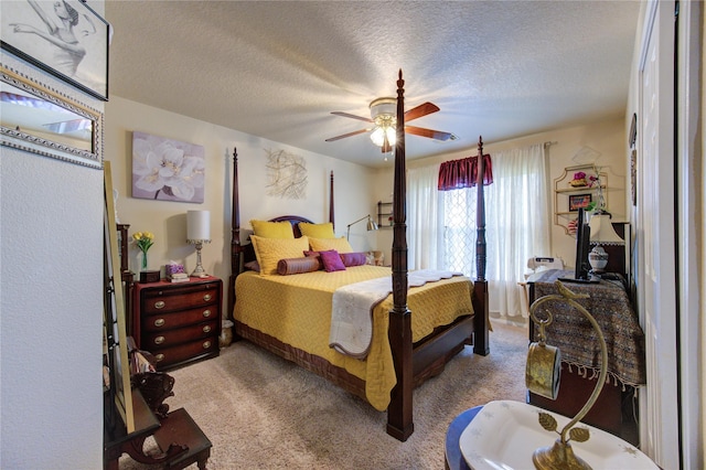 carpeted bedroom featuring a textured ceiling and ceiling fan