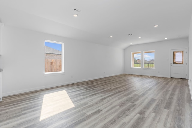 unfurnished living room featuring lofted ceiling and light wood-type flooring