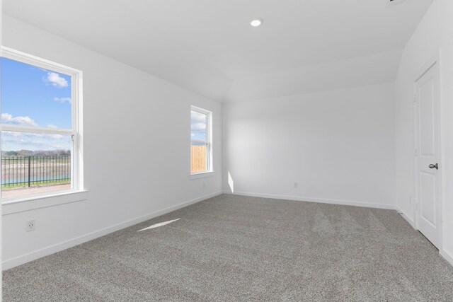 unfurnished room featuring carpet flooring and vaulted ceiling