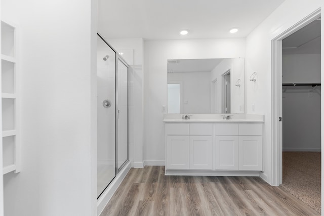 bathroom with vanity, wood-type flooring, and walk in shower