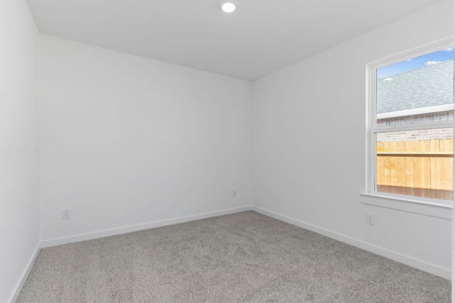 empty room with a wealth of natural light and carpet