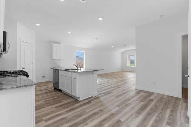 kitchen featuring a kitchen island with sink, sink, dishwasher, white cabinetry, and lofted ceiling