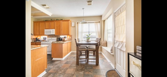 kitchen featuring a kitchen island, decorative light fixtures, and white appliances