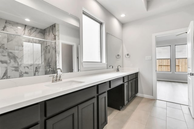 bathroom with tile patterned flooring, vanity, and walk in shower