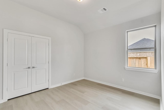 interior space with light hardwood / wood-style floors and vaulted ceiling