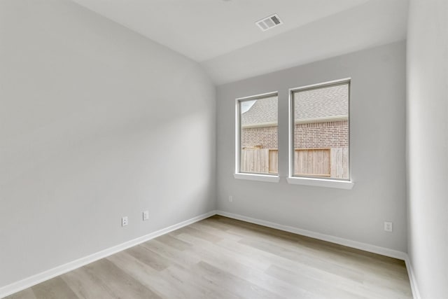 empty room featuring light hardwood / wood-style floors and lofted ceiling