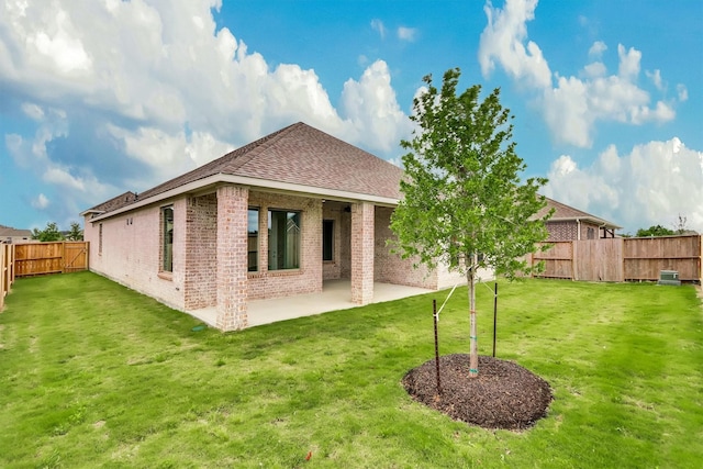 rear view of property featuring a patio area and a yard