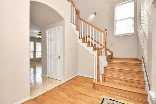 stairway with ceiling fan and hardwood / wood-style floors