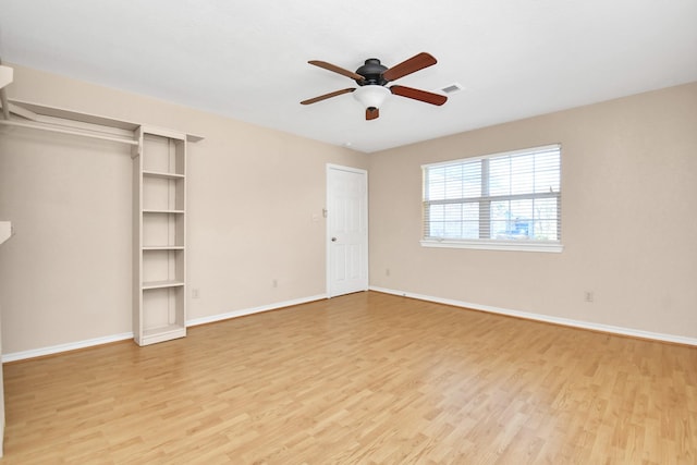 unfurnished bedroom with ceiling fan, light wood-type flooring, and a closet