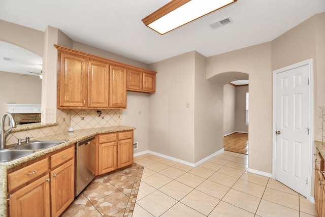 kitchen featuring decorative backsplash, stainless steel dishwasher, ceiling fan, sink, and light tile patterned flooring