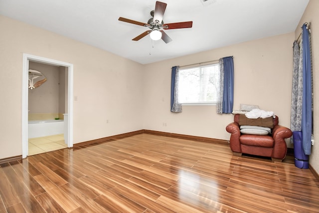 sitting room with hardwood / wood-style floors and ceiling fan