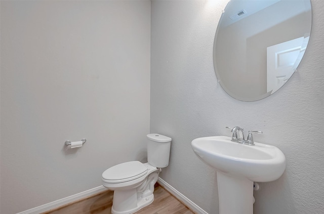 bathroom featuring hardwood / wood-style floors and toilet