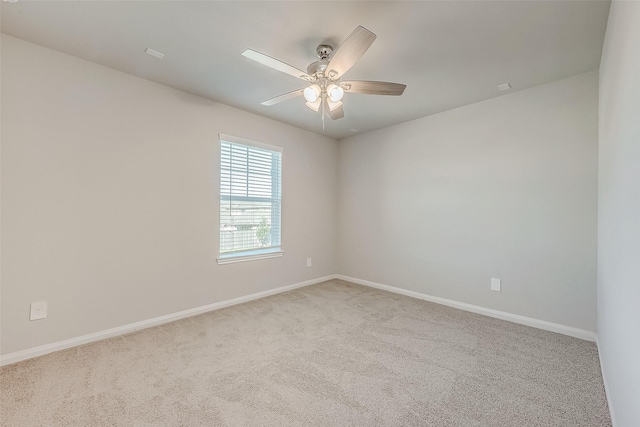 spare room with ceiling fan and light carpet