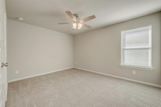 carpeted spare room with ceiling fan