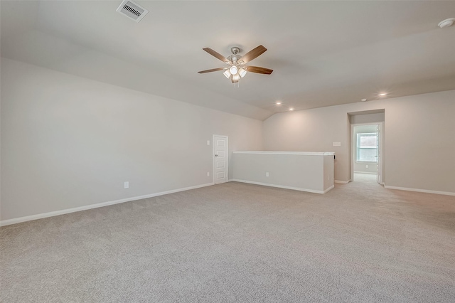 carpeted spare room with ceiling fan and vaulted ceiling