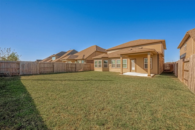 rear view of house featuring a lawn and a patio area