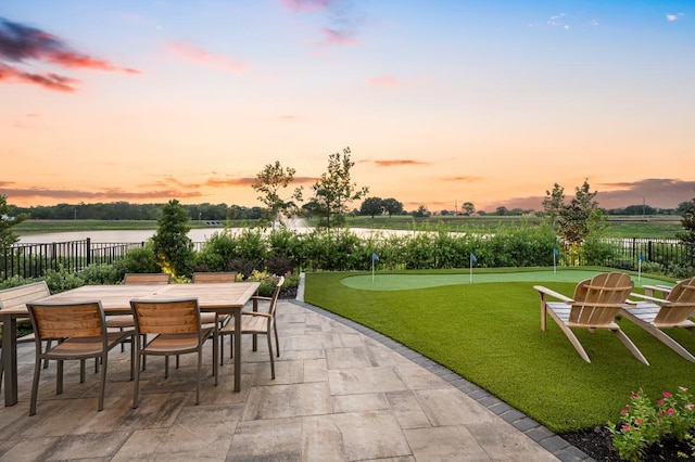 view of patio / terrace featuring outdoor dining space, a water view, and fence