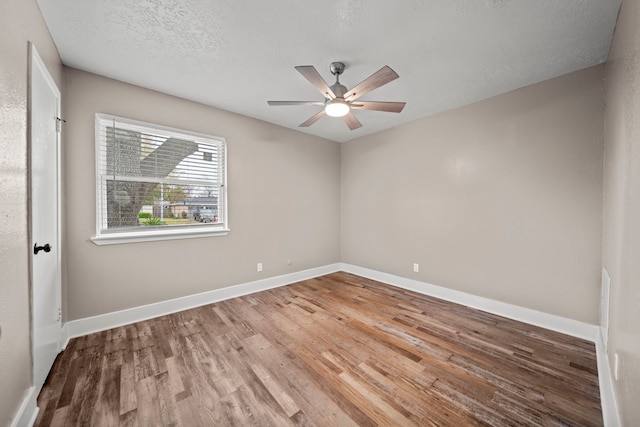 unfurnished room with ceiling fan, a textured ceiling, and wood-type flooring