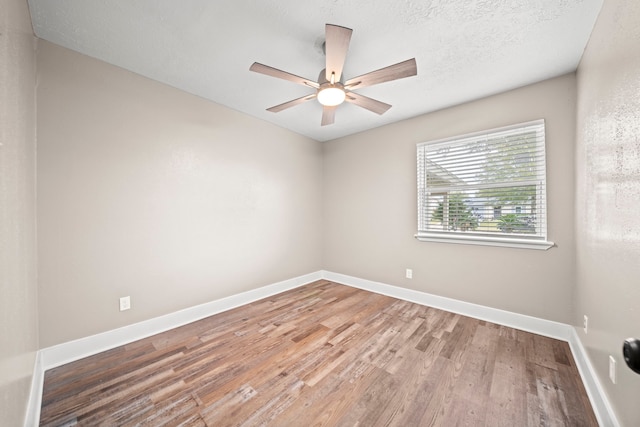 empty room with ceiling fan, hardwood / wood-style floors, and a textured ceiling