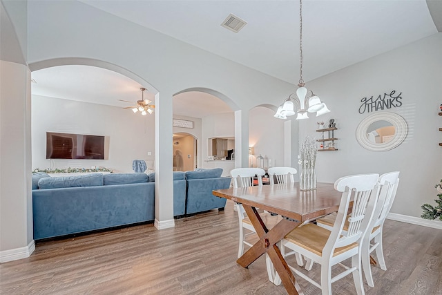 dining room featuring hardwood / wood-style floors and ceiling fan with notable chandelier