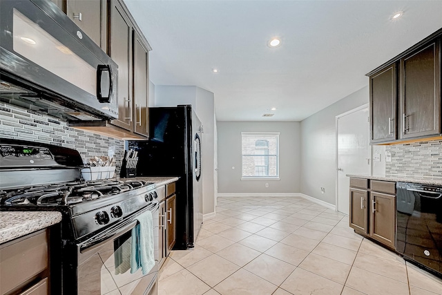 kitchen with backsplash, light stone counters, dark brown cabinets, black appliances, and light tile patterned floors