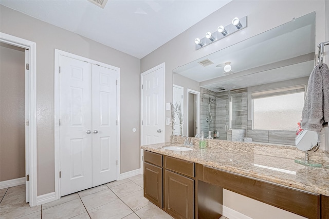 bathroom featuring tile patterned flooring, vanity, and a shower with shower door