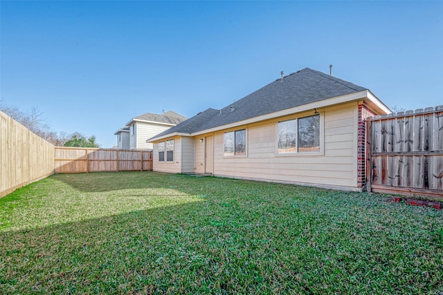 rear view of property featuring a lawn