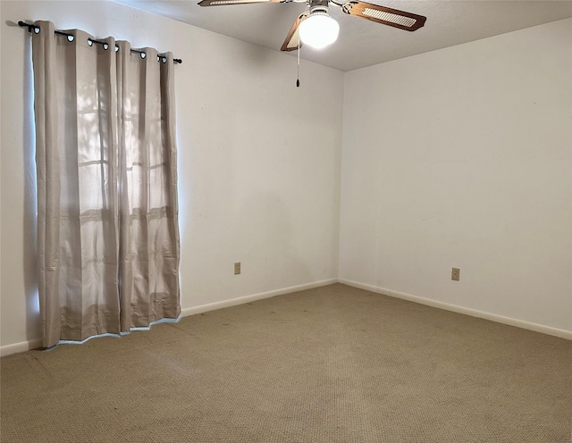 carpeted spare room featuring ceiling fan