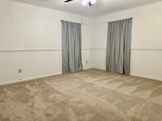 spare room featuring carpet, ceiling fan, and a textured ceiling