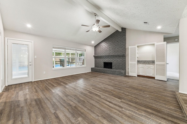 unfurnished living room with ceiling fan, vaulted ceiling with beams, dark hardwood / wood-style floors, a textured ceiling, and a fireplace