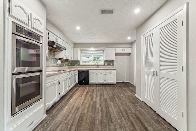 kitchen with white cabinets, black appliances, dark hardwood / wood-style floors, a textured ceiling, and tasteful backsplash