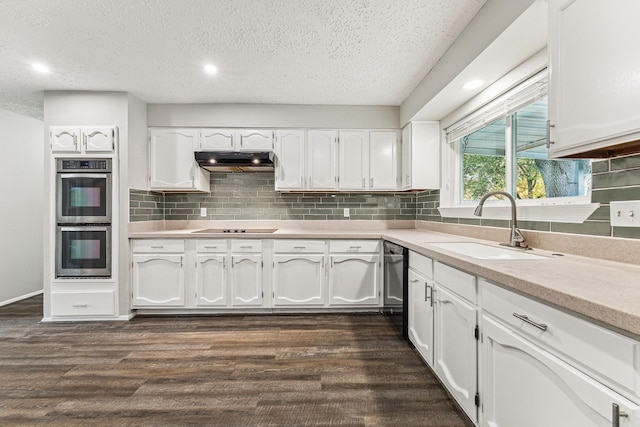 kitchen featuring dark wood-type flooring, white cabinets, and stainless steel double oven