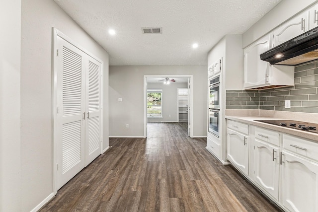 kitchen with gas cooktop, dark hardwood / wood-style flooring, tasteful backsplash, a textured ceiling, and white cabinets