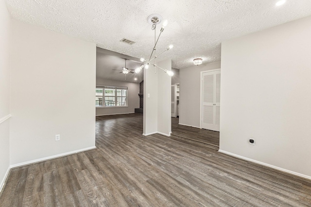 interior space featuring a textured ceiling, ceiling fan, and dark wood-type flooring