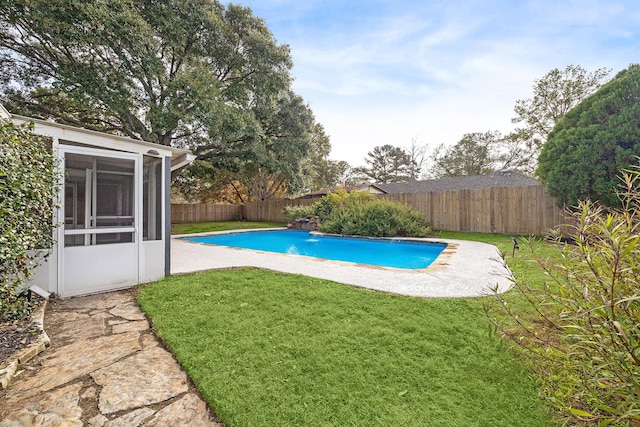 view of pool with a yard and a sunroom