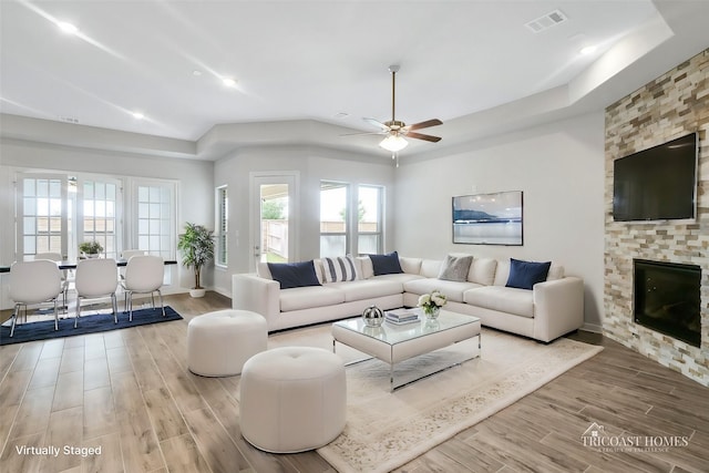 living room featuring ceiling fan and a fireplace