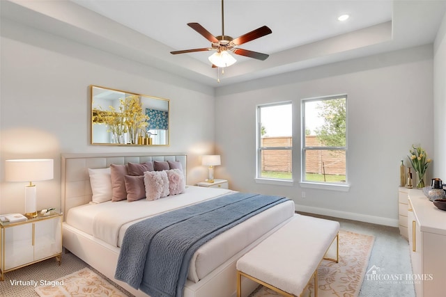 bedroom with a raised ceiling and ceiling fan