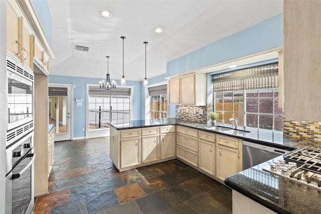 kitchen with kitchen peninsula, decorative backsplash, stainless steel appliances, and plenty of natural light