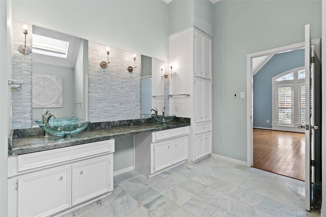 bathroom with vanity, wood-type flooring, lofted ceiling with skylight, and a shower