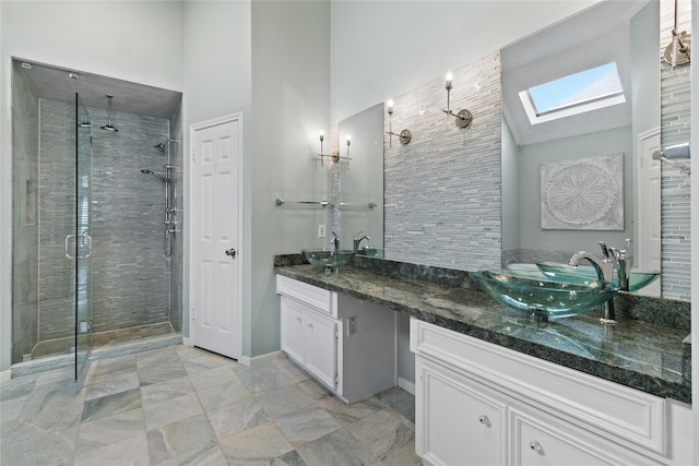 bathroom with a skylight, vanity, high vaulted ceiling, and walk in shower